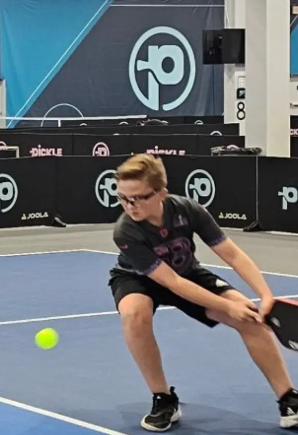 Jett ripping a two handed backhand at Picklemall wearing his black Adidas Barricade shoes